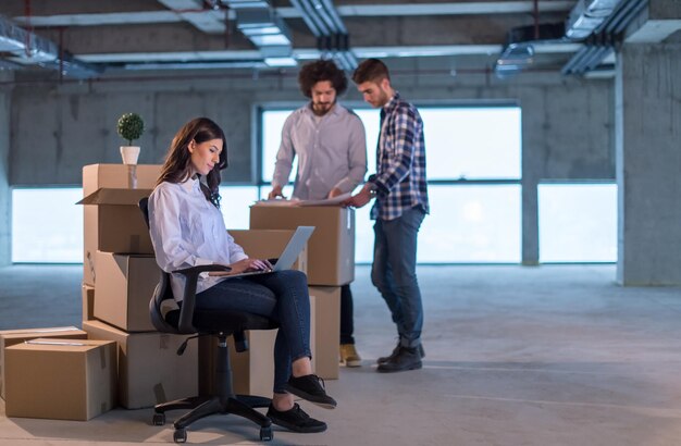 young team of business people in group, architect and engineer on construction site checking documents and business workflow using laptop computer in new startup office