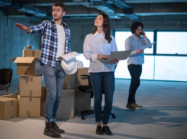 young team of business people in group, architect and engineer on construction site checking documents and business workflow using laptop computer in new startup office