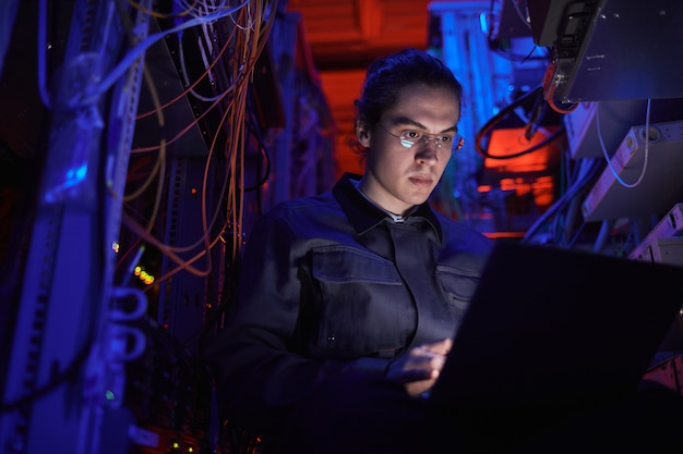 Young technician setting up internet network in server room