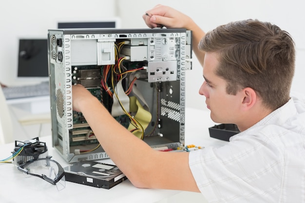 Foto giovane tecnico che lavora al computer rotto