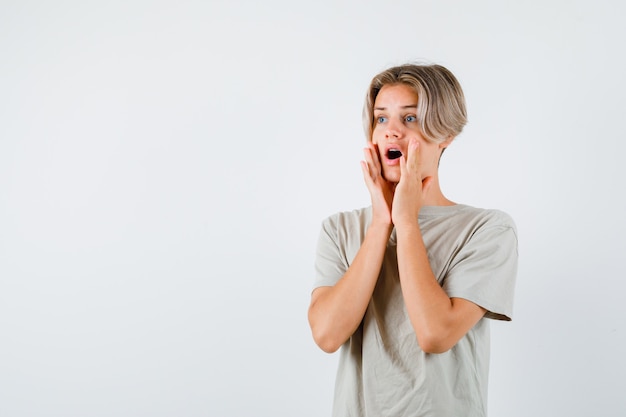 Young teen boy with hands near mouth