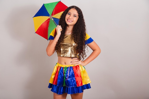 Молодая бразильская девушка-подросток в одежде frevo карнавал с зонтиком и руками на талии
