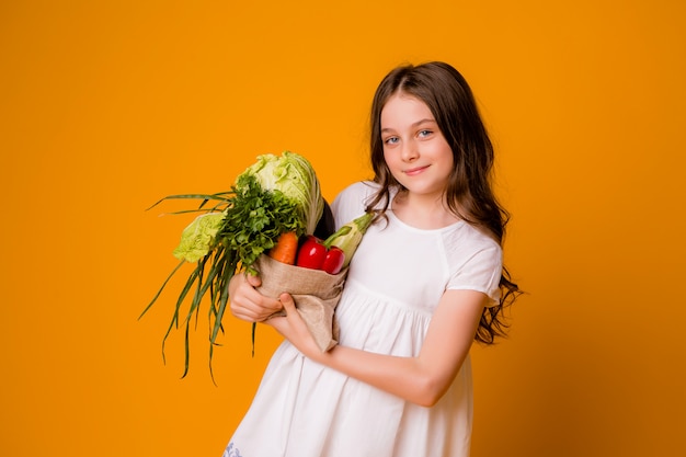 Молодая девушка с мешком овощей