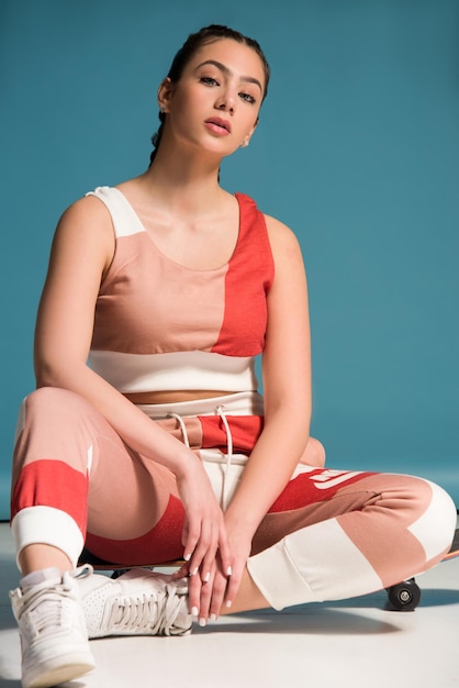 Young teen girl with skateboard studio shot