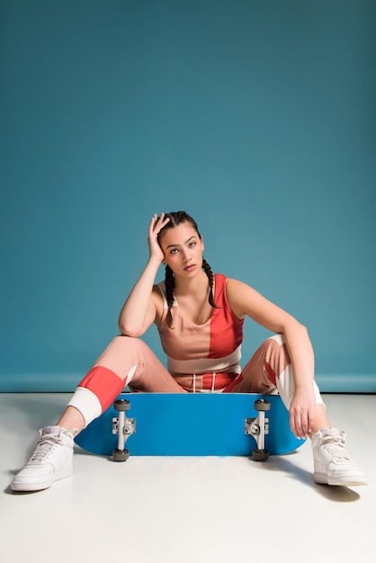 Young teen girl with skateboard studio shot