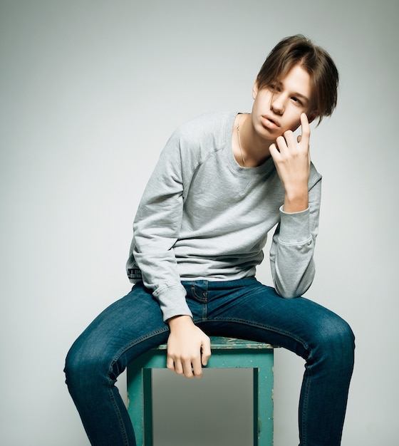 A young teenage boy being photographed in a studio.