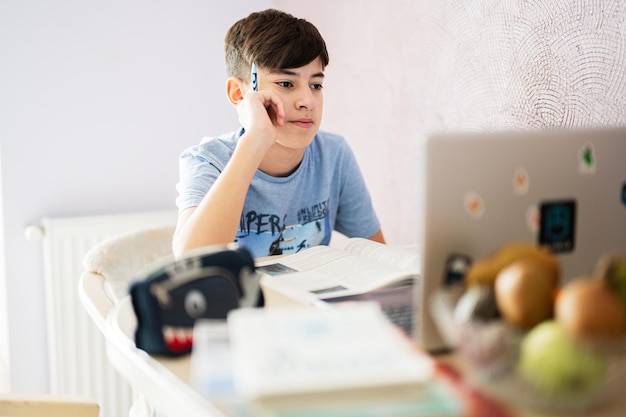 Young teenage boy having video conference call with pupil using webcam Online education and elearning concept Home quarantine distance learning