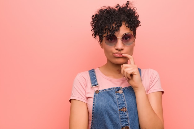 Young teenage girl looking sideways with doubtful and skeptical expression