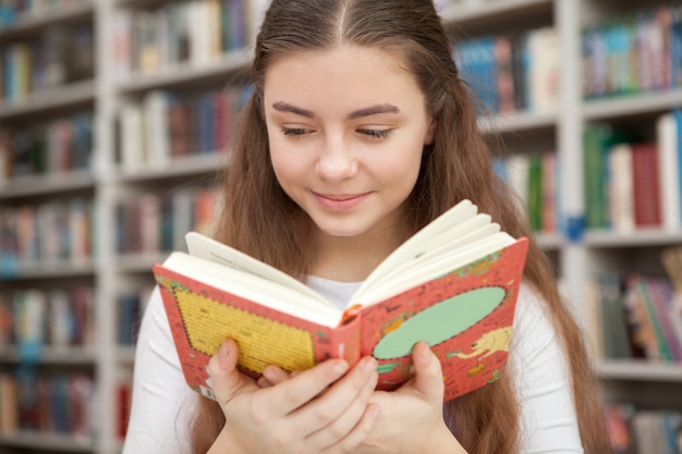 Young teenage girl studying at the library