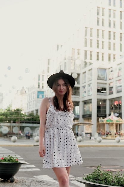 Young teenage girl in a white dress and hat