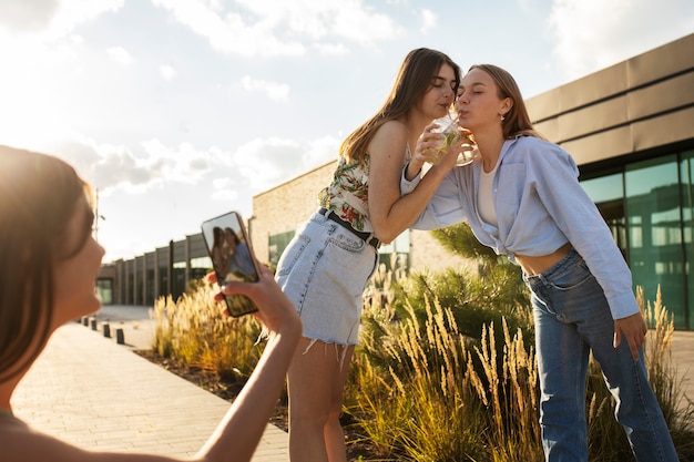 Young teenage girls recording reels of themselves outdoors for social media