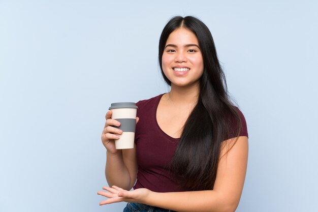 Ragazza asiatica del giovane adolescente che tiene un caffè asportabile