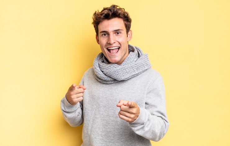 Photo young teenager boy feeling happy, cool, satisfied, relaxed and successful, pointing at camera, choosing you