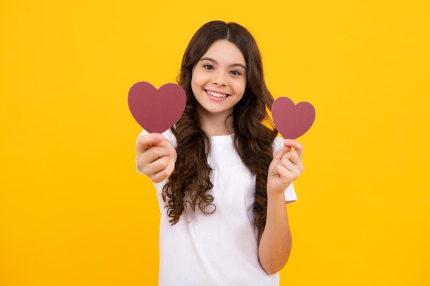 Young teenager child girl with heart shape Happy Valentines Day Love and pleasant feelings concept Happy teenager positive and smiling emotions of teen girl