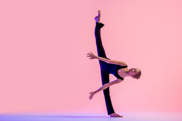 Фото Молодой танцор подростка танцует на красной предпосылке студии. балет, танец, искусство, современность, концепция хореографии
