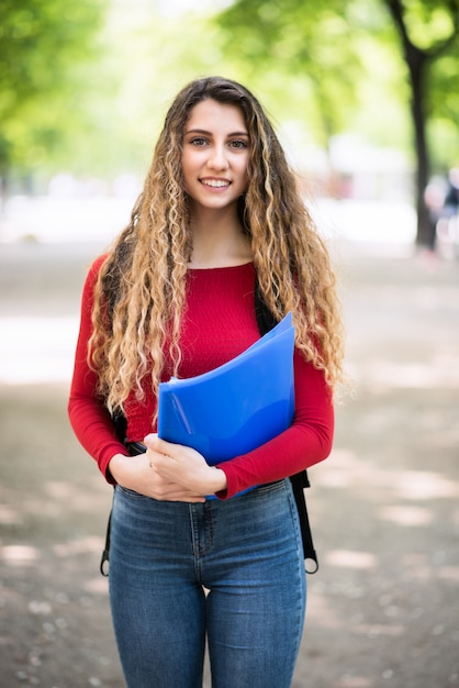 Young teenager female student walking in the school park