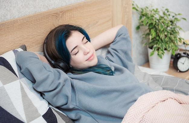 Young teenager girl with blue hair and  headphones