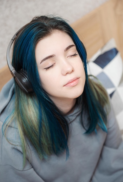 Young teenager girl with blue hair and  headphones