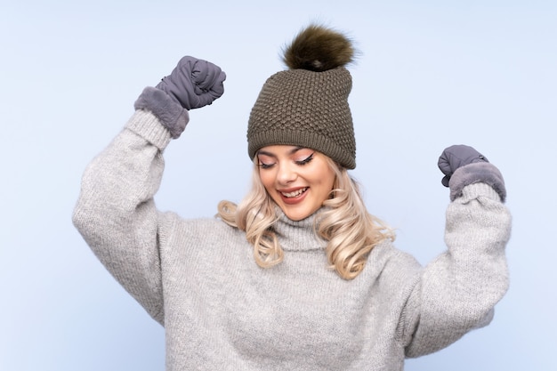 Young teenager girl with winter hat celebrating a victory
