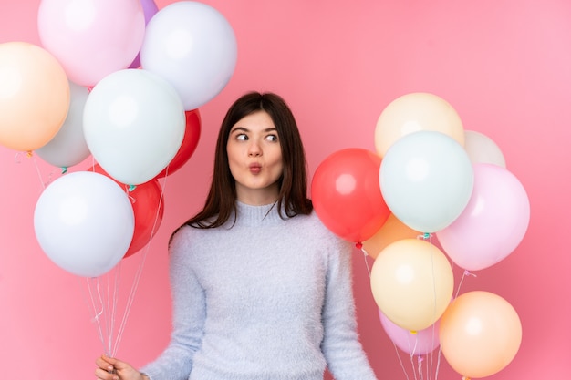 Young teenager holding lots of balloons