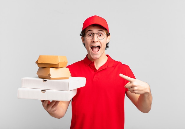 Young teenager man young pizza deliver man pointing or showing