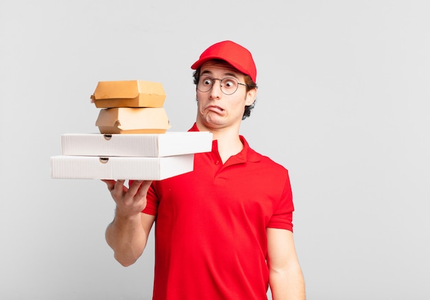 Young teenager man young pizza deliver man scared expression