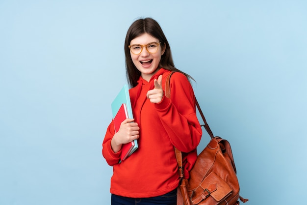 Young teenager student woman holding a salad points finger at you