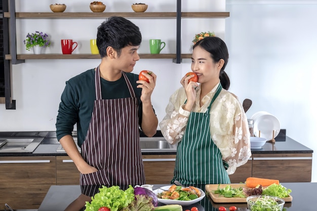 Young teenagers eating tomatoes