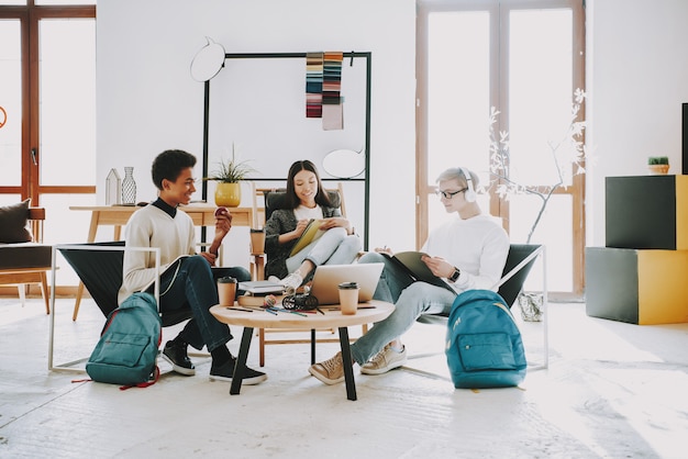 Foto giovani adolescenti che si siedono in poltrone in coworking