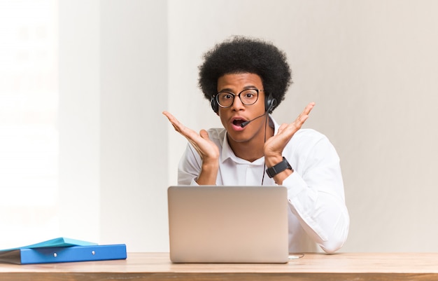 Young telemarketer african american man surprised and shocked