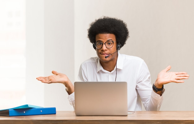 Young telemarketer black man confused and doubtful