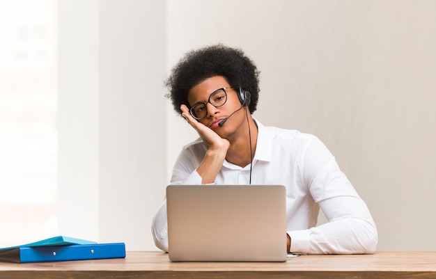 Young telemarketer black man tired and very sleepy