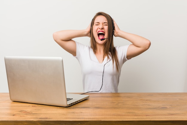 Young telemarketer woman covering ears with hands trying not to hear too loud sound.