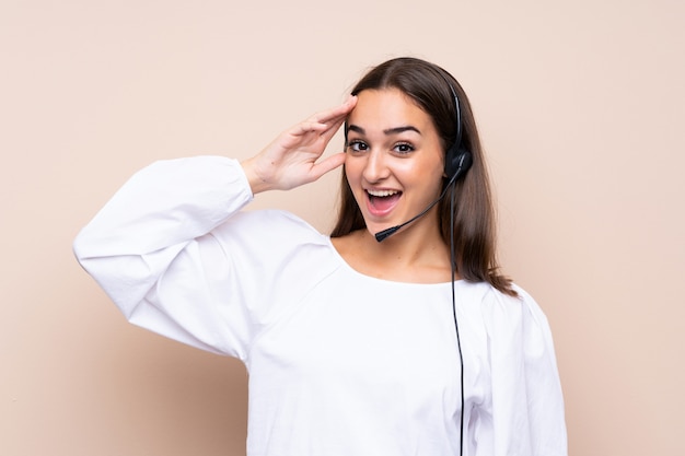 Young telemarketer woman over isolated background with surprise and shocked facial expression