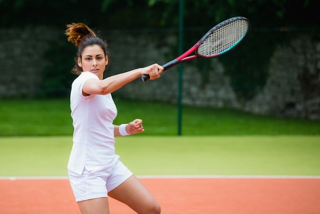 Giovane tennista che colpisce palla