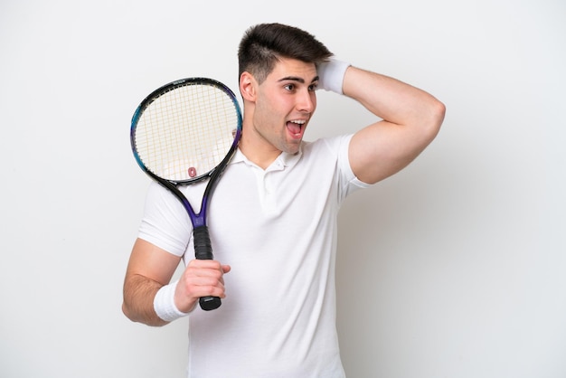 Young tennis player man isolated on white background doing surprise gesture while looking to the side