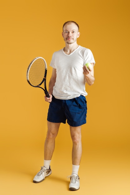 Young tennis player plays tennis on a yellow