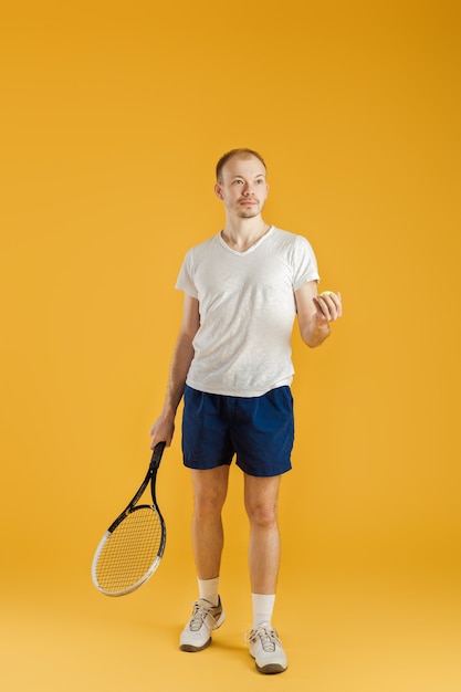 Young tennis player plays tennis on a yellow