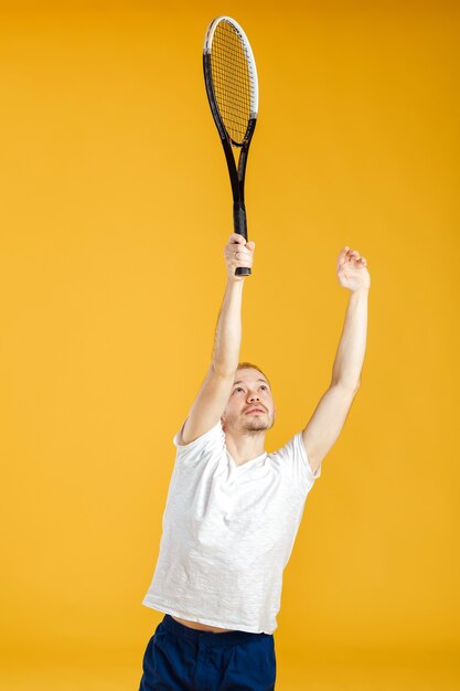 Young tennis player plays tennis on a yellow