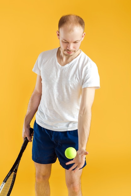 Young tennis player plays tennis on a yellow