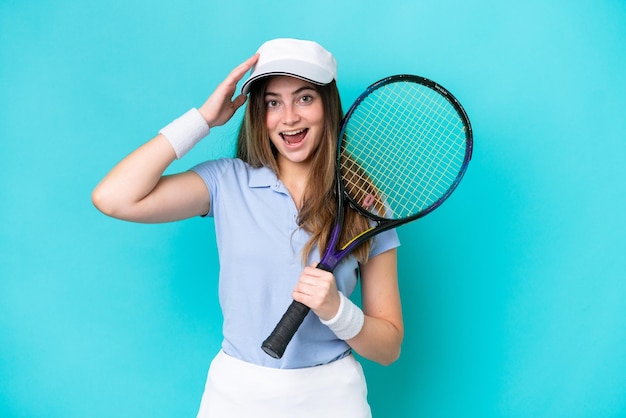 Young tennis player woman isolated on blue background with surprise expression