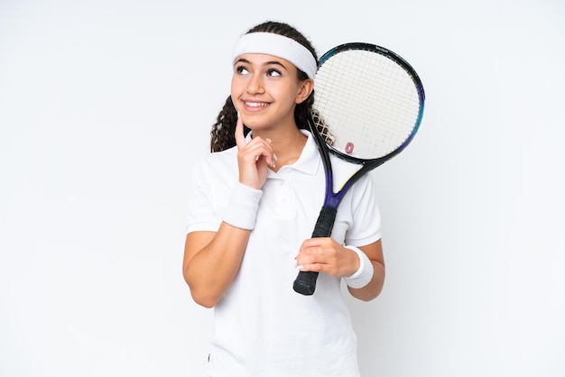 Young tennis player woman isolated on white background thinking an idea while looking up