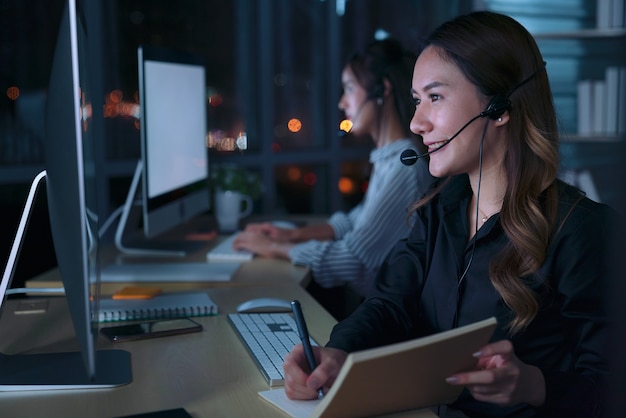 Young Thai Asian customer services care operators working night shift in call center