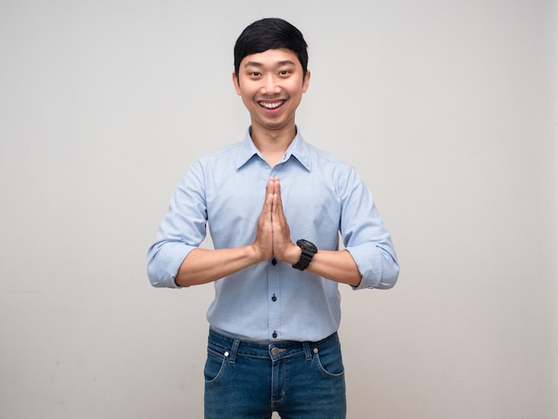 Young thai man gesture respect hand with happy smile isolated