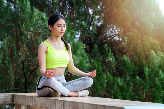 Young Thai woman in sportswear meditating 