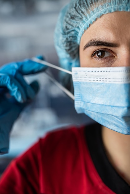Молодая усталая медсестра или врач снимают маску после смены в медицинской клинике