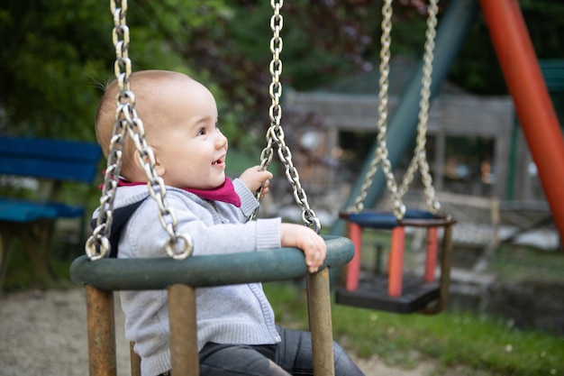 公園で安全に座っている若い幼児の男の子