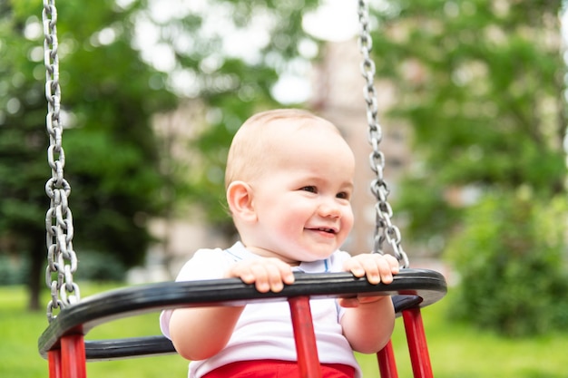 Foto un giovane bambino che oscilla in un parco