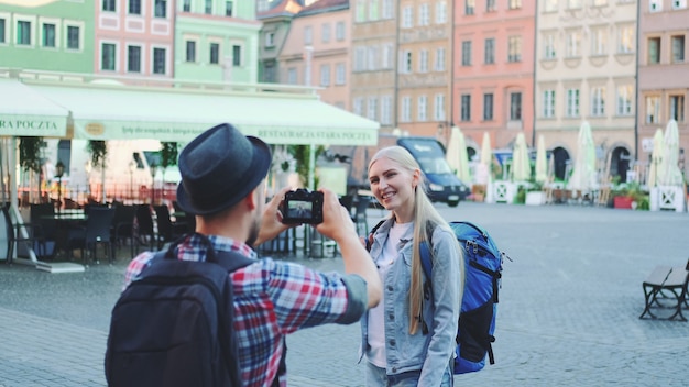 Young tourist couple making photos on the view of historical buildings