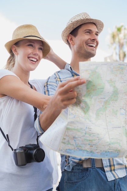 Photo young tourist couple using the map